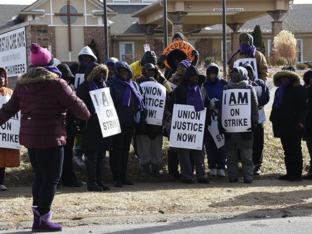 A group of workers from Christian Care Home and community members gathers outside of the facility to protest unfair labor laws.