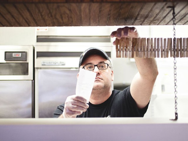 Chris Makos, one of the owners of Boodles, reading orders behind the counter. See a slideshow of Boodles BBQ.