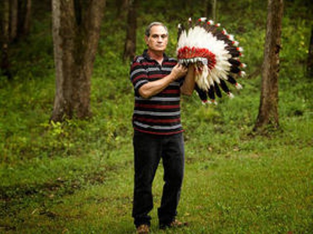 Kevin Airis and one of his grandfather's Native American headdresses.