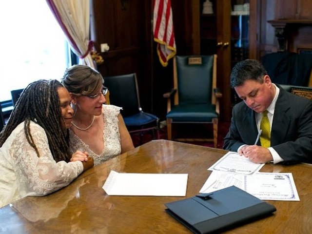 Miranda Duschack and Mimo Davis complete the paperwork portion of their marriage ceremony.