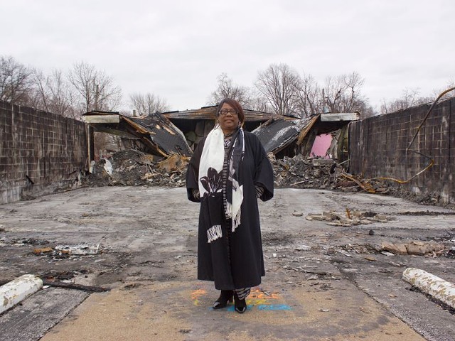 Juanita Morris stands in front of the remains of her store, Fashion R Boutique, which was burned down in the rioting over Michael Brown's death.