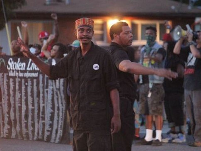 In this August 14 photo, Olajuwon Ali, left, helps direct traffic during a celebratory protest in Ferguson. Ali, whose legal name is Olajuwon Davis, was indicted last week on weapons charges.