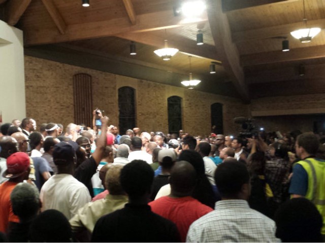 Rev. Al Sharpton surrounded by young men on stage at Greater St. Mark's Missionary.