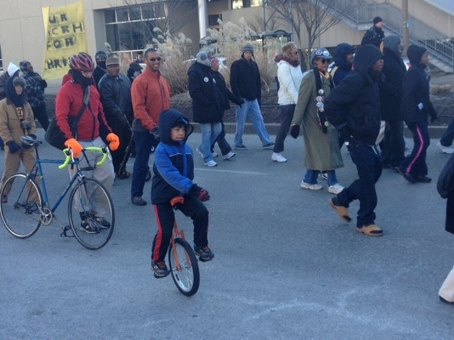 Finn McNamee, eight, rides his unicycle in the MLK parade yesterday. Big photos below.
