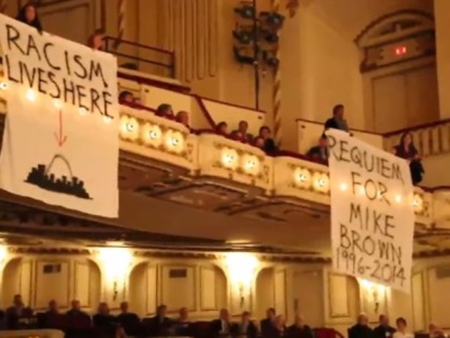 Protesters unfurl banners during the SLSO performance.