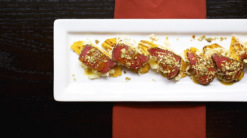 Ahi Tuna Tostadas, one of the &#xFFFD;Fresh Beginnings&#xFFFD; on the menu, is comprised of seared rare tuna with lime slaw, mango Habanero sauce and toasted pepitas on a crisped plantain chip. See more photos from inside Kota Wood Fire Grill.