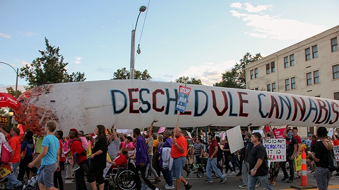 Legalization supporters carry a giant inflatable joint near the site of the 2016 presidential debate in St. Louis.
