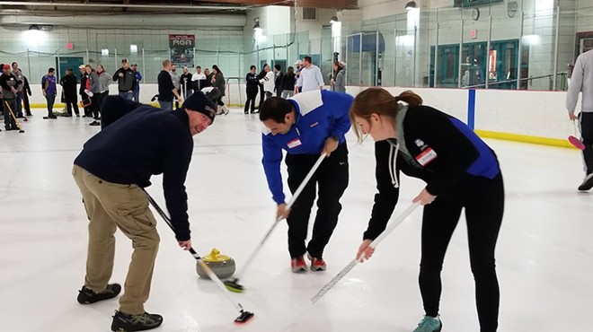 Curling novices sweep the ice in front of the granite stone during an instructional group session from the St. Louis Curling Club.