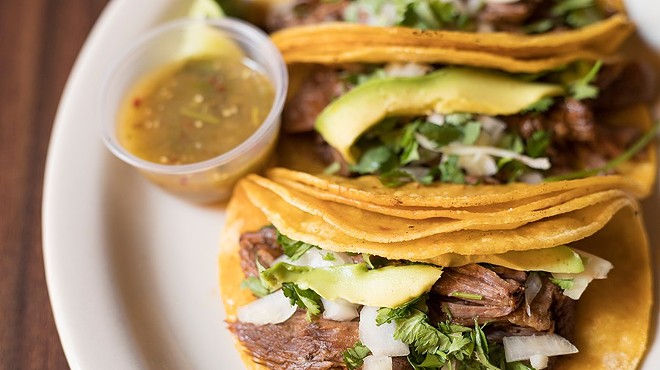 Tacos with slow-cooked beef, onions, cilantro and avocado.