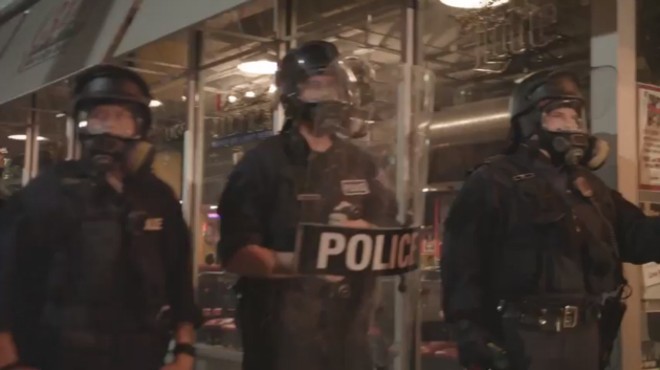 A video still from the kettle shows riot police walling off the intersection of Washington and Tucker.