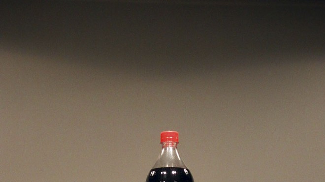Installation view of Helmut Smits' oil filled Coca-Cola bottle.