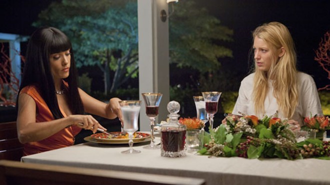 Salma Hayek dines with her prisoner, O (Blake Lively), in Savages, the thriller from filmmaker Oliver Stone.