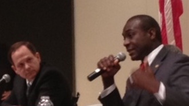 Francis Slay listens to opponent Lewis Reed at a debate last night.