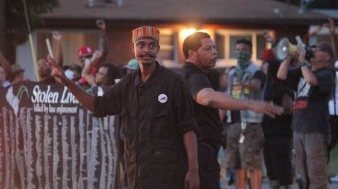 In this August 14 photo, Olajuwon Ali, left, helps direct traffic during a celebratory protest in Ferguson. Ali, whose legal name is Olajuwon Davis, was indicted last week on weapons charges.