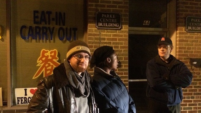 Greg Hilderbrand and Laura Charles guard their apartment Monday night in Ferguson.