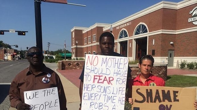 In the original photo, the middle sign says mothers should fear for their sons' lives when they leave the house, not rob a store.