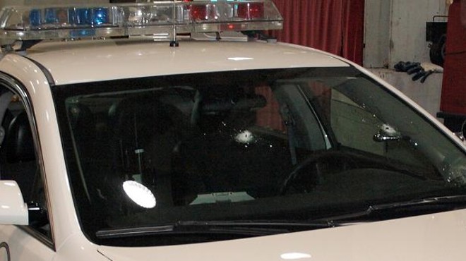 The police cruiser bears two bullet holes in the windshield.