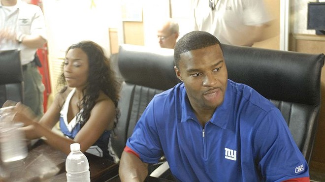 Umenyiora signing autographs on a USO tour.