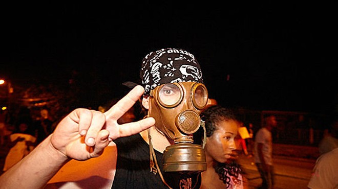 A demonstrator protects his face from tear gas in Ferguson.