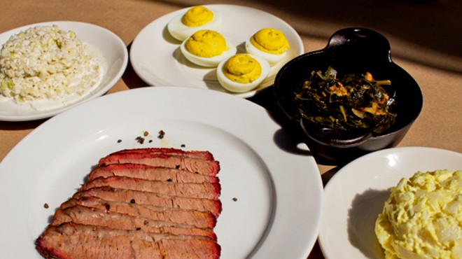 Smoked brisket with sides of cole slaw, deviled eggs, bacon braised greens and potato salad.