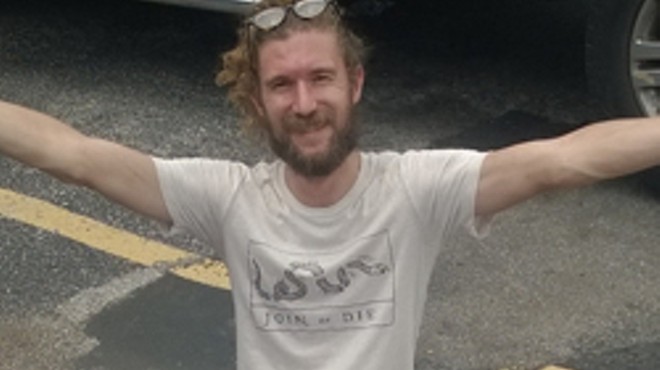 Colin Dean of Radio Birds posing with a shirt they found in their recovered van