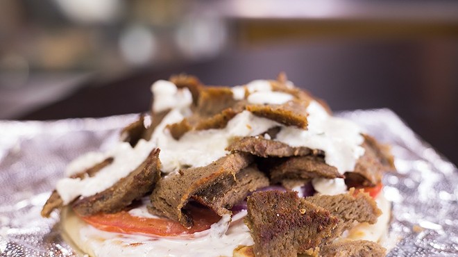 Gyro with lamb-beef combo on flat bread with tomato, red onion and tzatziki sauce.