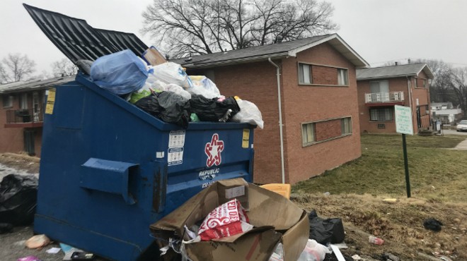 Dumpsters overflow with trash at Blue Fountain Apartments.