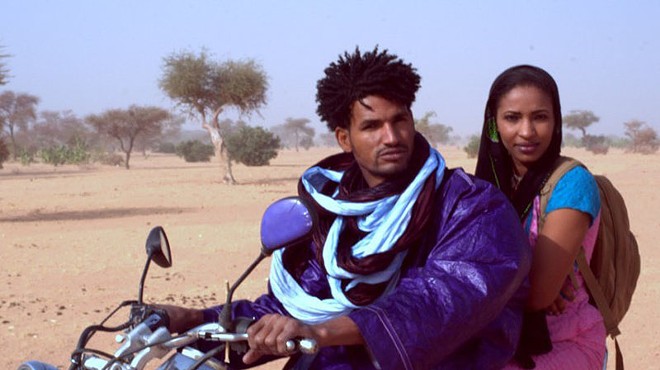 Mdou (Mdou Moctar) and Rhaicha (Rhaicha Ibrahim) race through the Sahara in Akounak Tedalat Taha Tazoughai.