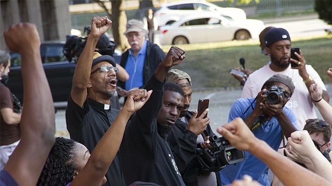 State Representative Bruce Franks Jr. leads protesters in a chant on the steps of St. Louis City Hall.