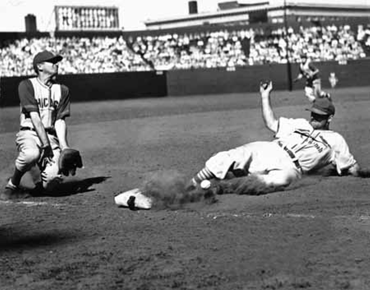1940. The Cardinals' Pepper Martin steals third base on the Cubs' Stan Hack.