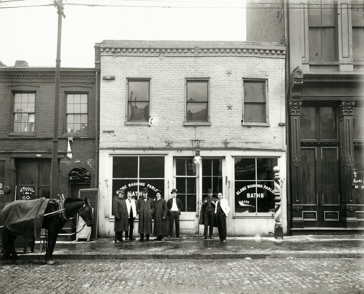 Group of men standing in front of the Globe Shaving Parlor at 1015 Carr. Photograph, ca. 1910. In the surrounding blocks lived Italians, Yiddish-speaking Russians and Hungarians, and African American families from the South.