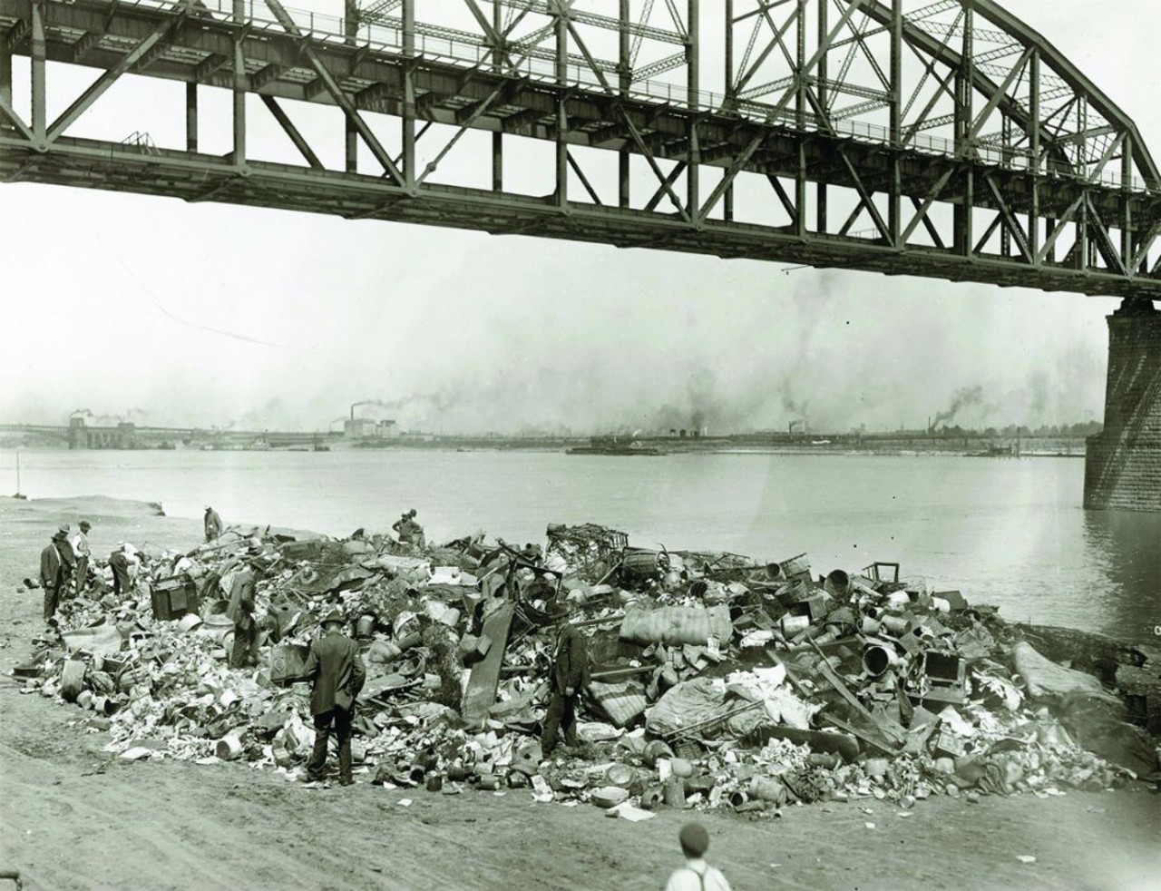 Men going through a rubbish pile on the riverfront south of Municipal Free Bridge (MacArthur). Photograph, 1910.