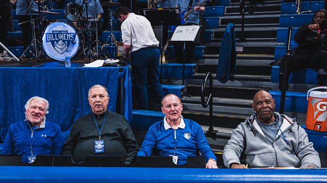 (From left) Mike Van Hecke, Mike Owens, Ken Mraz and Ron Golden sit at a blue table in front of bleachers and a band.