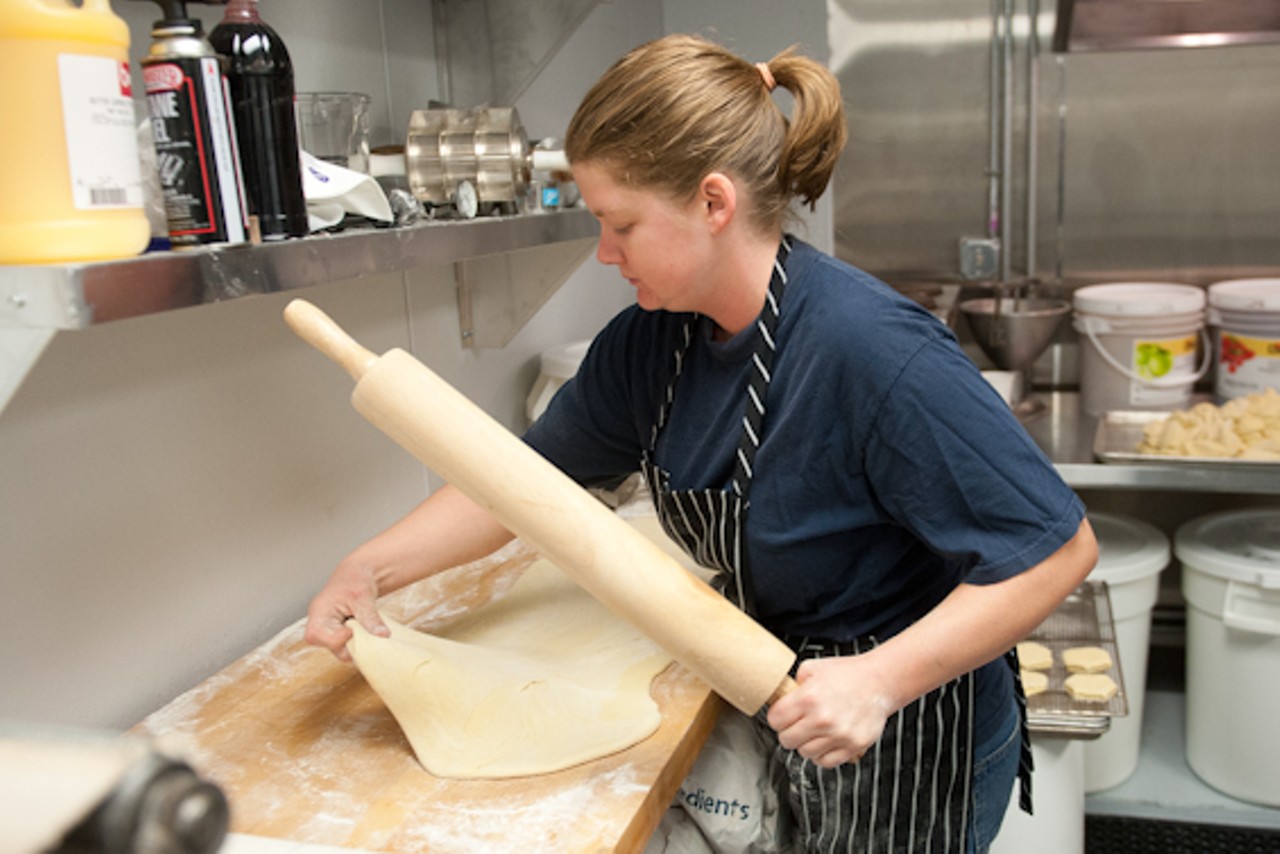Amelia Tufts works with some dough in the kitchen as patrons line up outside before Strange Donuts opens.&nbsp;