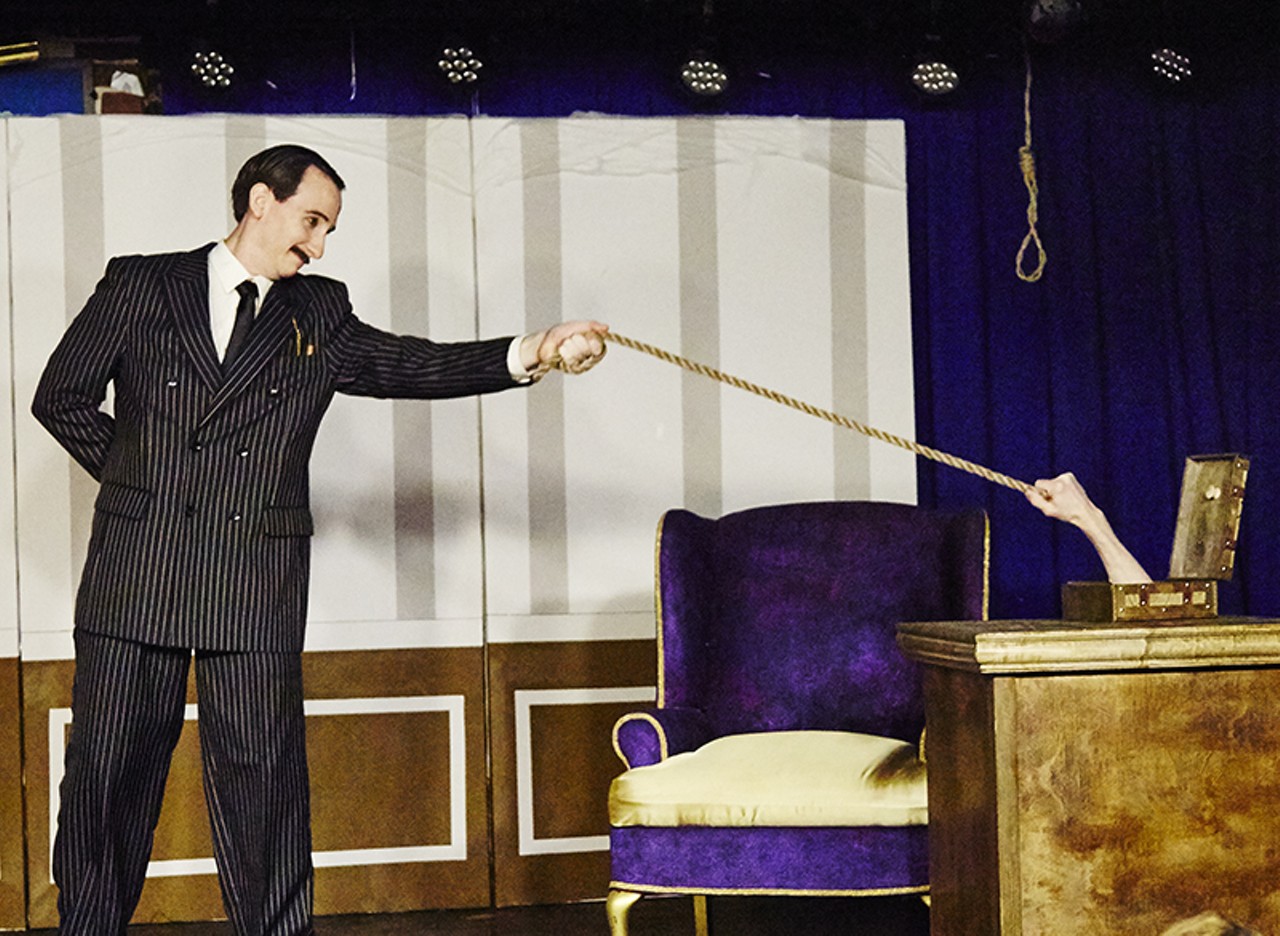 Gomez Addams and Thing have a tug of war.