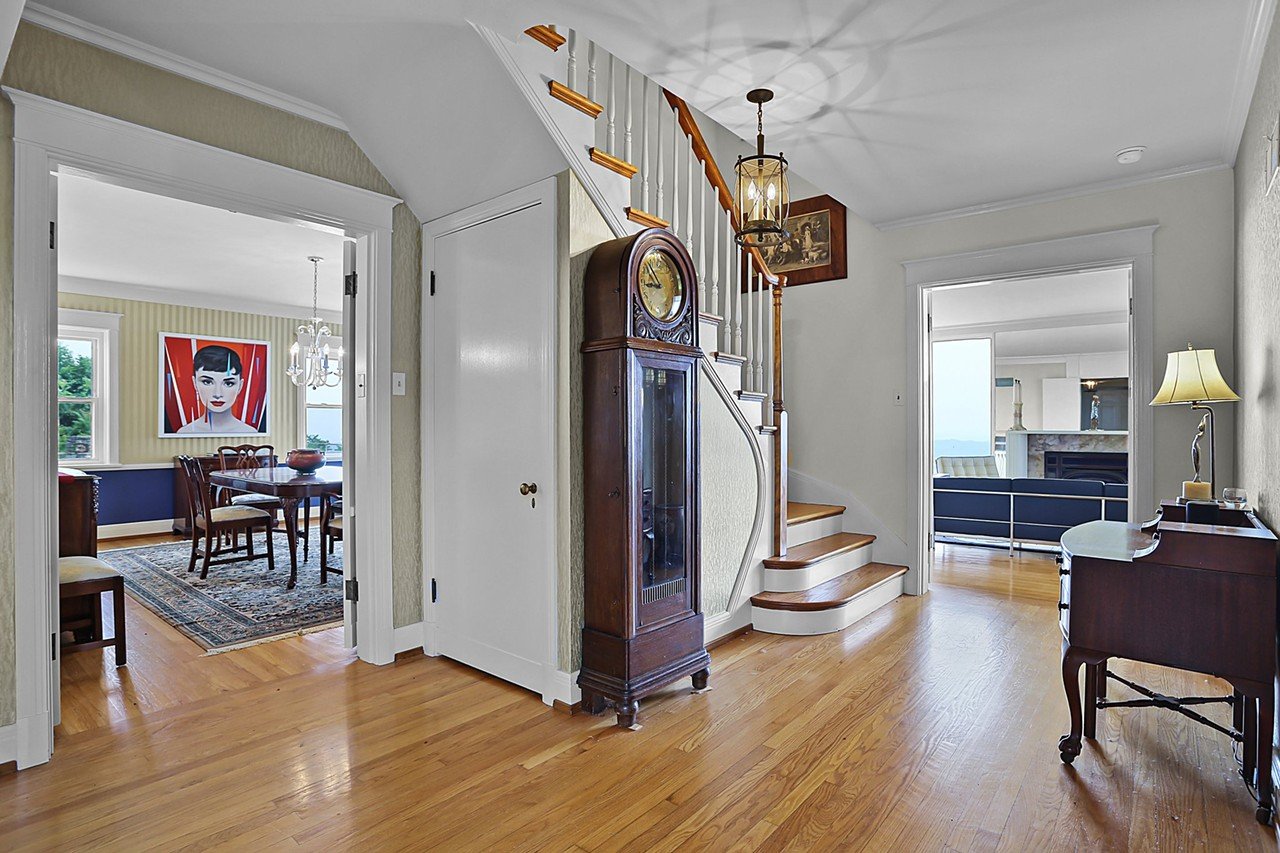 The generous foyer is the heart of the house, and features refinished hardwood floors and elegant wallpaper.