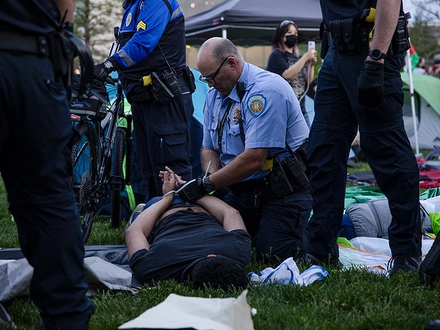 A police officer zip ties a protestor on the campus of Washington University on Saturday, April 27.