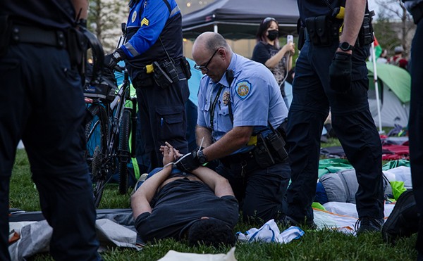 A police officer zip ties a protestor on the campus of Washington University on Saturday, April 27.