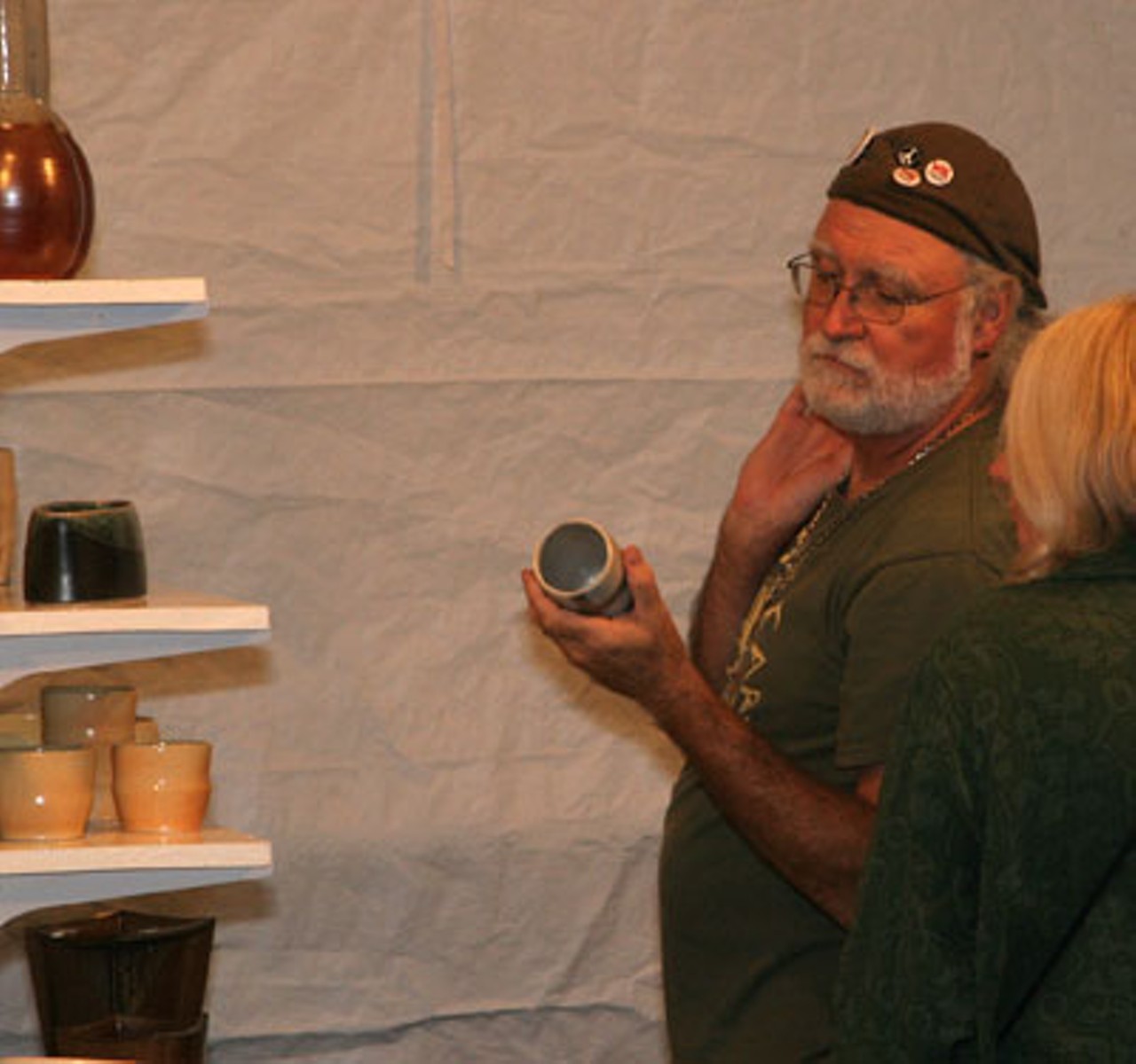 A couple examines Susanne Harmon's ceramic creations at Art Outside.