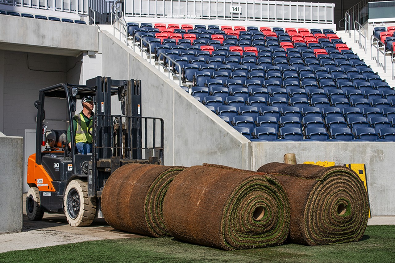Andrew Marking brings spools of new sod to replace the old field.