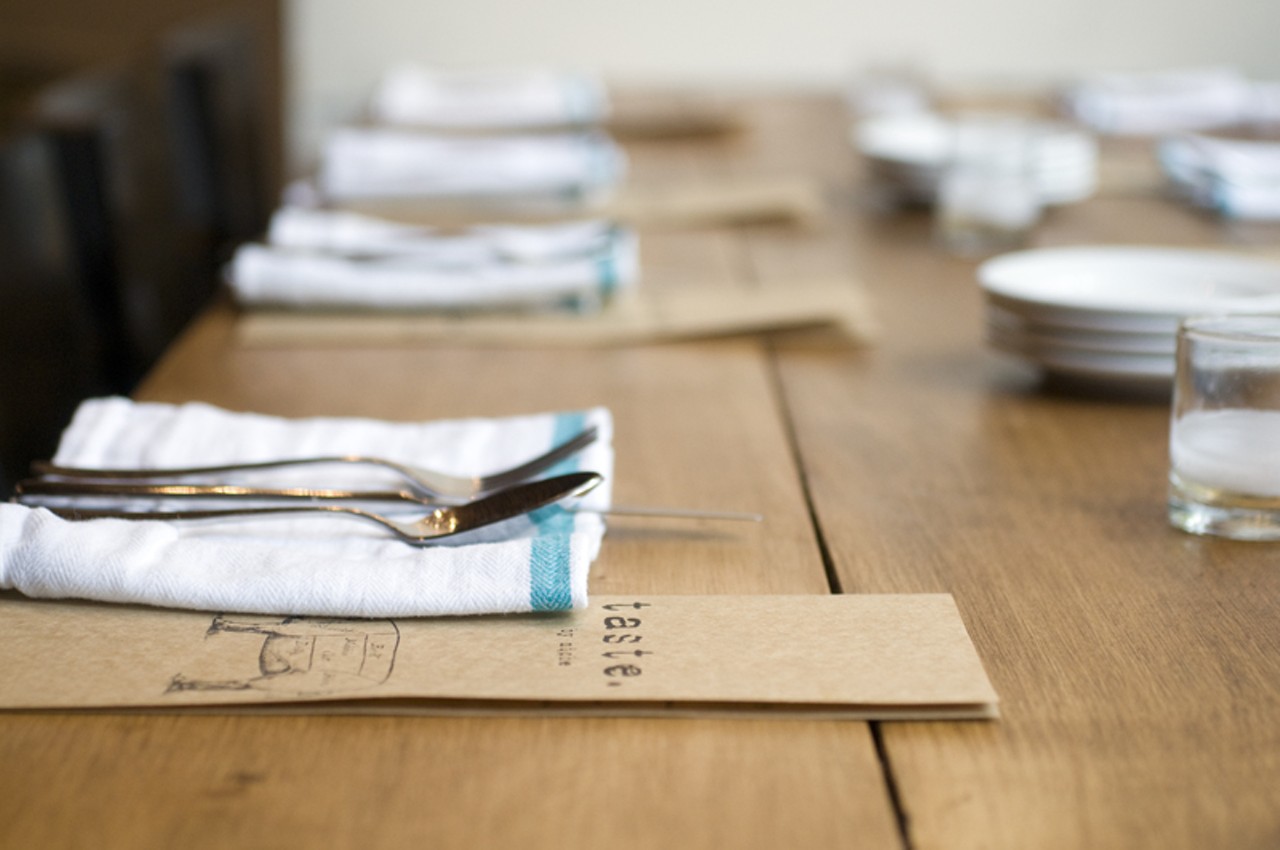 The table settings at Taste are simple. Here, linen-striped napkins sit on on a rustic wood table.