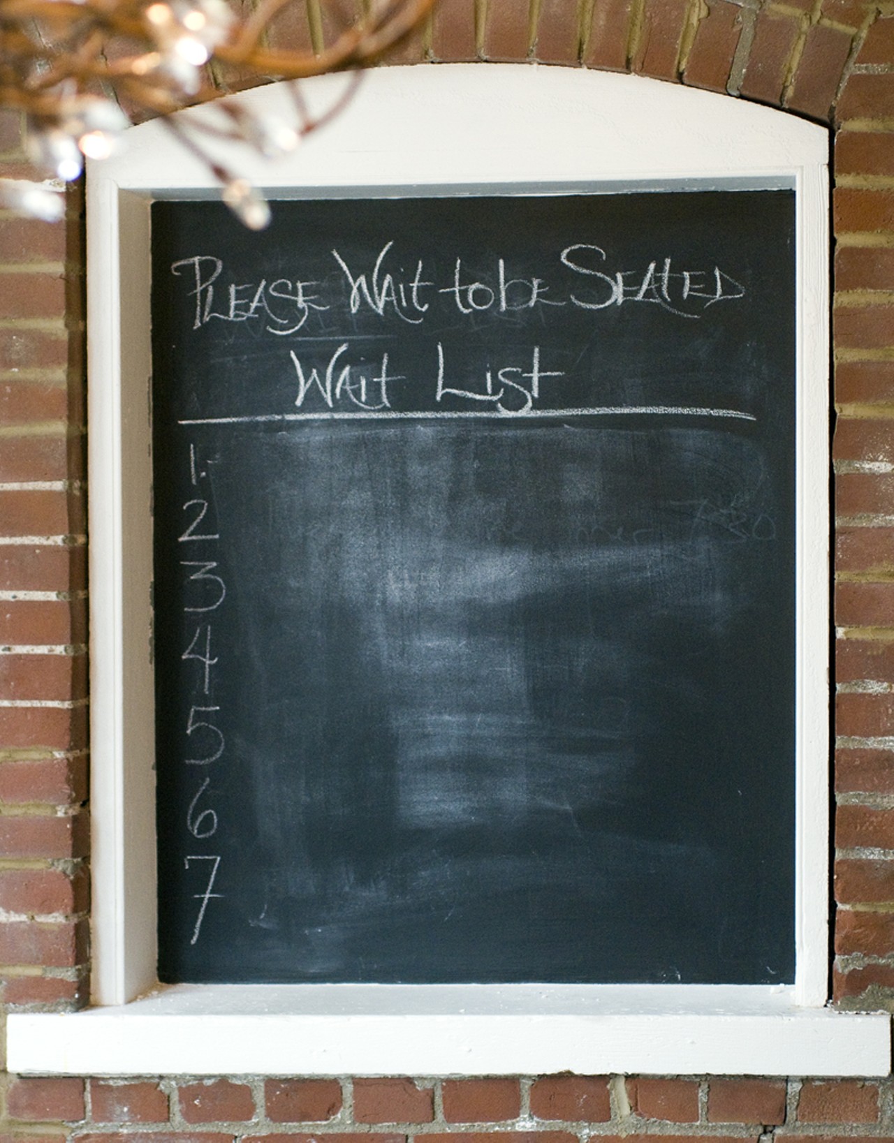 The chalkboard wait list, located by the front door of Taste.