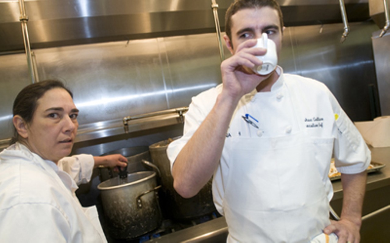 Executive chef Josh Galliano sips his morning coffee while stage, Barbara Greenberg, checks on one of the stocks.