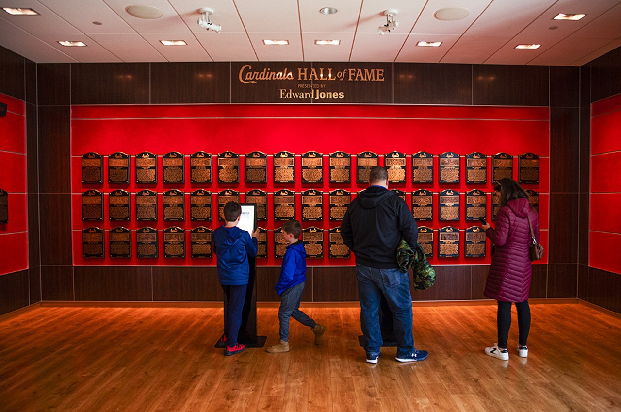 A family inspects the Hall of Fame wall inside the St. Louis Cardinals Hall of Fame and Museum at Ballpark Village.