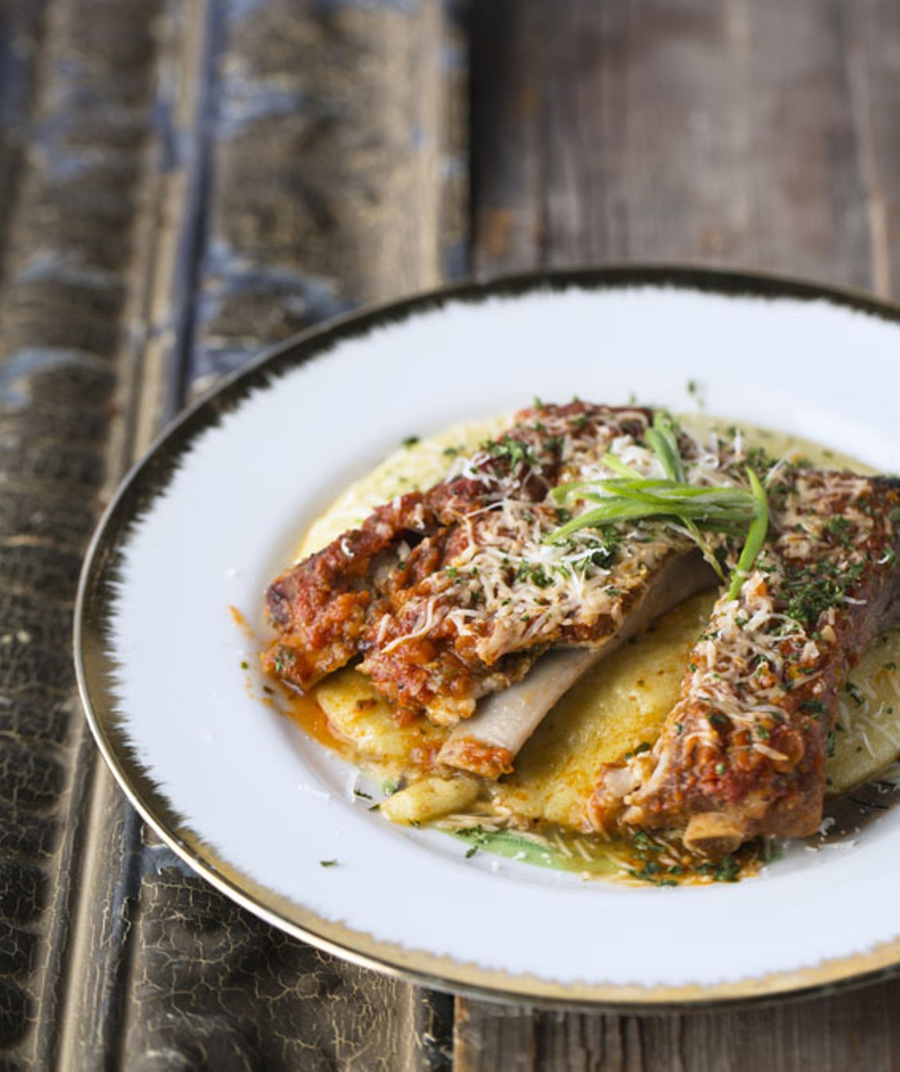 The St. Louis-cut pork ribs are brined overnight and braised in housemade bourbon marinara, then broiled and topped with fresh parmigiano and scallions.