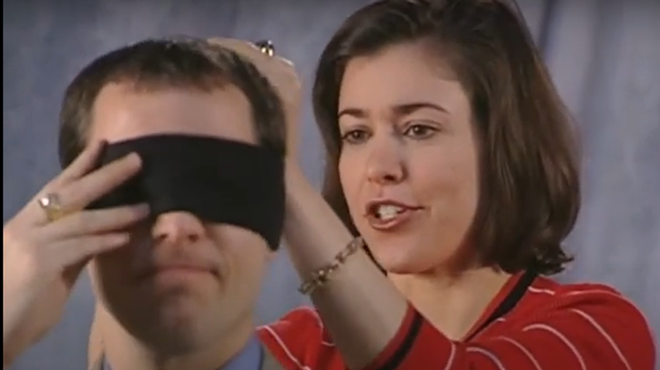 Brook is blindfolded by Amy to test how well he knows the furniture in a classic Carol House Furniture ad.