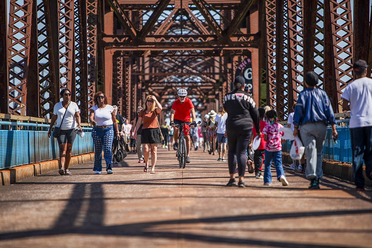 Cyclists and pedestrians walk across the Chain of Rocks Bridge.