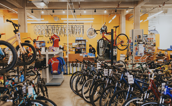 Bikes are packed into a room with a yellow background.
