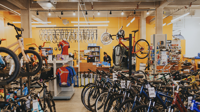 Bikes are packed into a room with a yellow background.