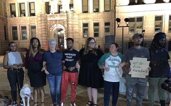 Advocates for homeless St. Louisans, including both current and former aldermen, link arms outside City Hall to oppose a planned camp dispersal.